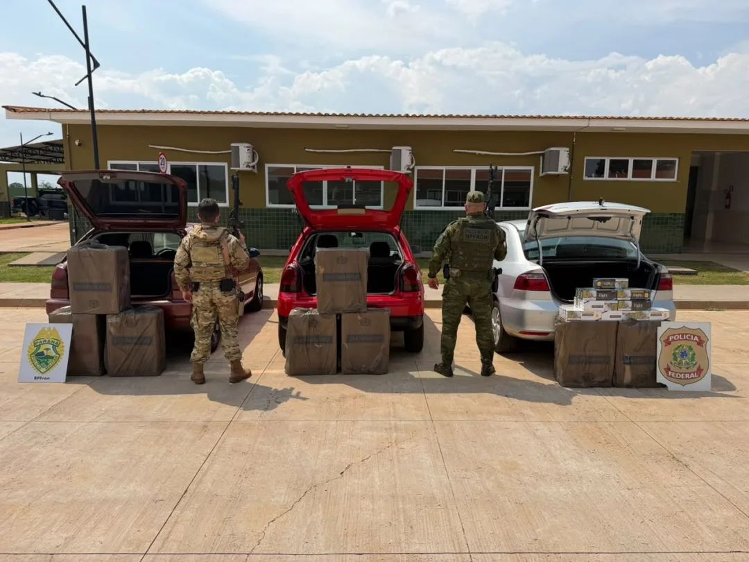 Viaturas policiais e veículos apreendidos carregados com caixas de cigarros contrabandeados do Paraguai