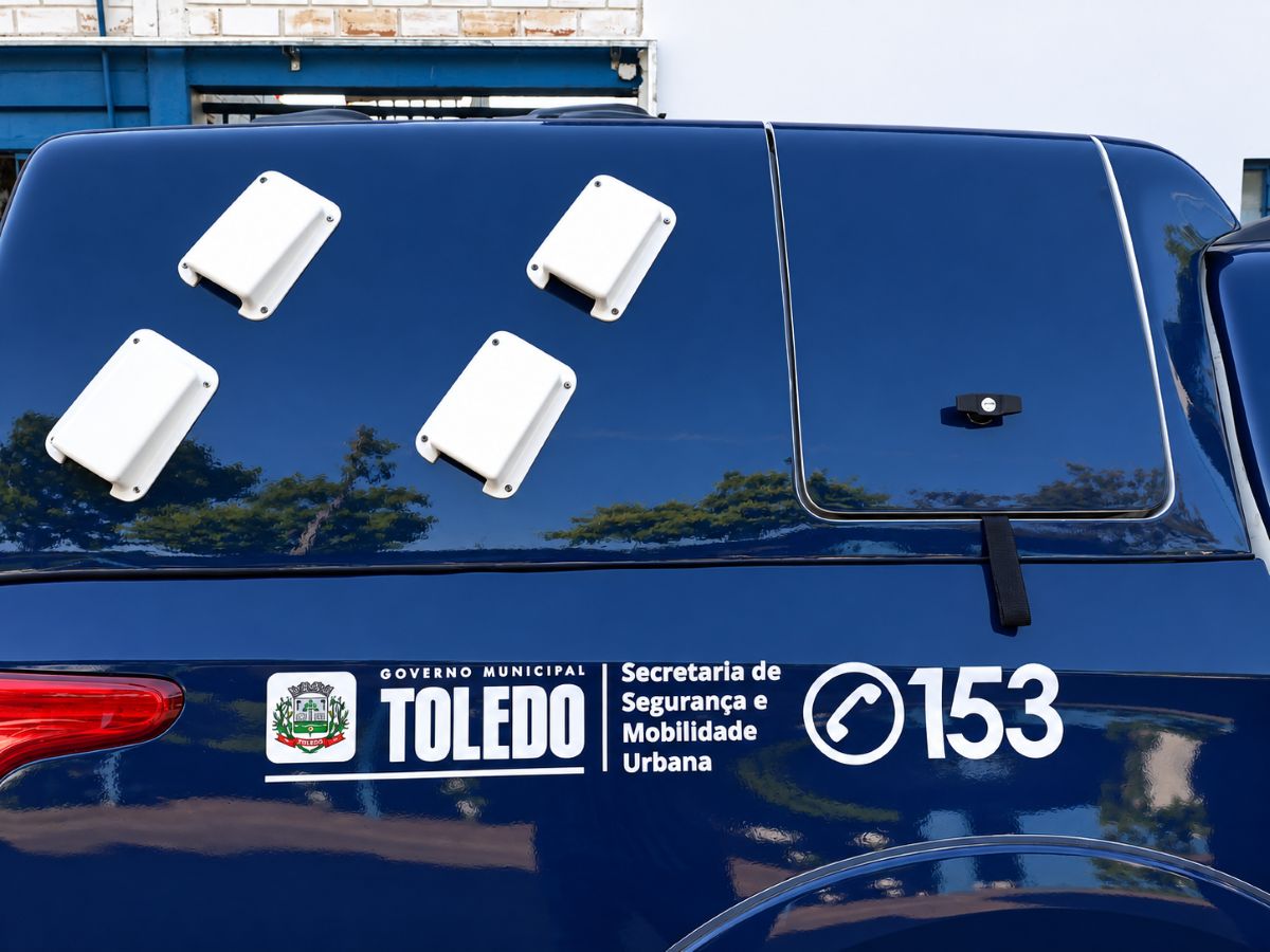 Veículos sendo abordados em blitz de trânsito na Avenida Parigot de Souza, em Toledo, com a presença de agentes da Guarda Municipal e Polícia Militar.