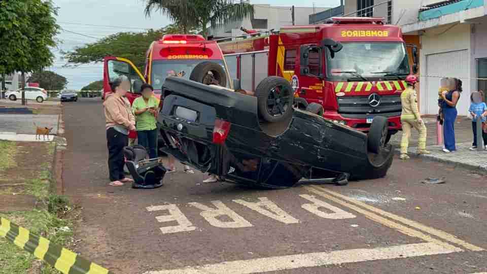 Veículo Volkswagen Parati capotado após colisão com Chevrolet Agile em cruzamento movimentado próximo a uma escola no bairro Santa Felicidade