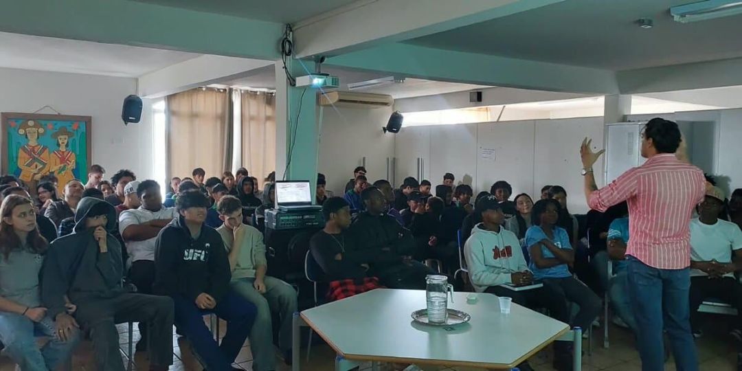 Representantes da FAG Toledo em visita a um colégio estadual, conversando com alunos e professores sobre os cursos oferecidos.