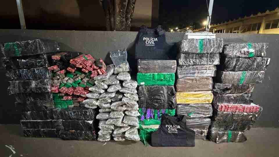Policiais civis em Foz do Iguaçu exibem os fardos e tabletes de maconha apreendidos em ação