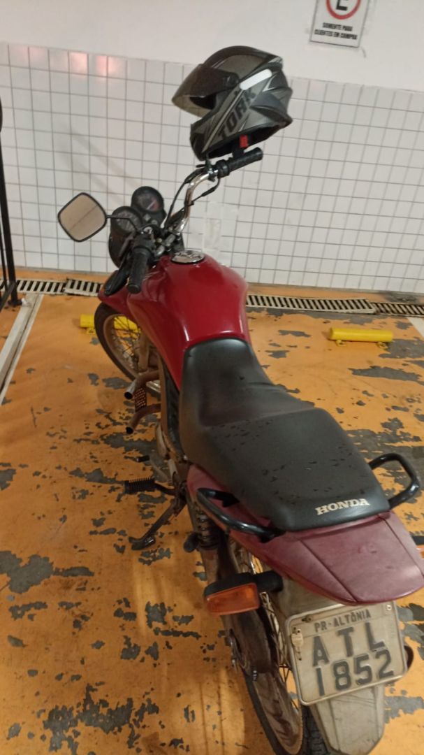 Modelo de motocicleta Honda CG vermelha estacionada em via urbana em Toledo