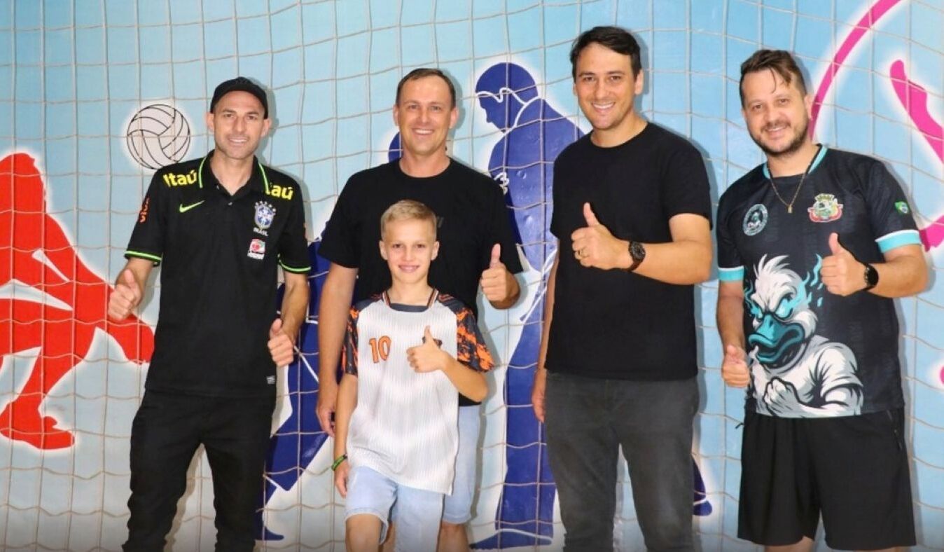 Jovem atleta Otávio Fincke sorrindo em quadra de futsal com uniforme esportivo