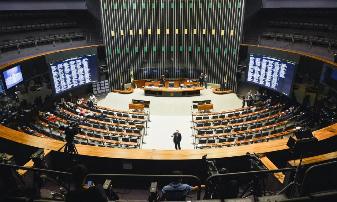 Urna eletrônica em seção eleitoral com eleitor votando para as eleições legislativas no Paraná