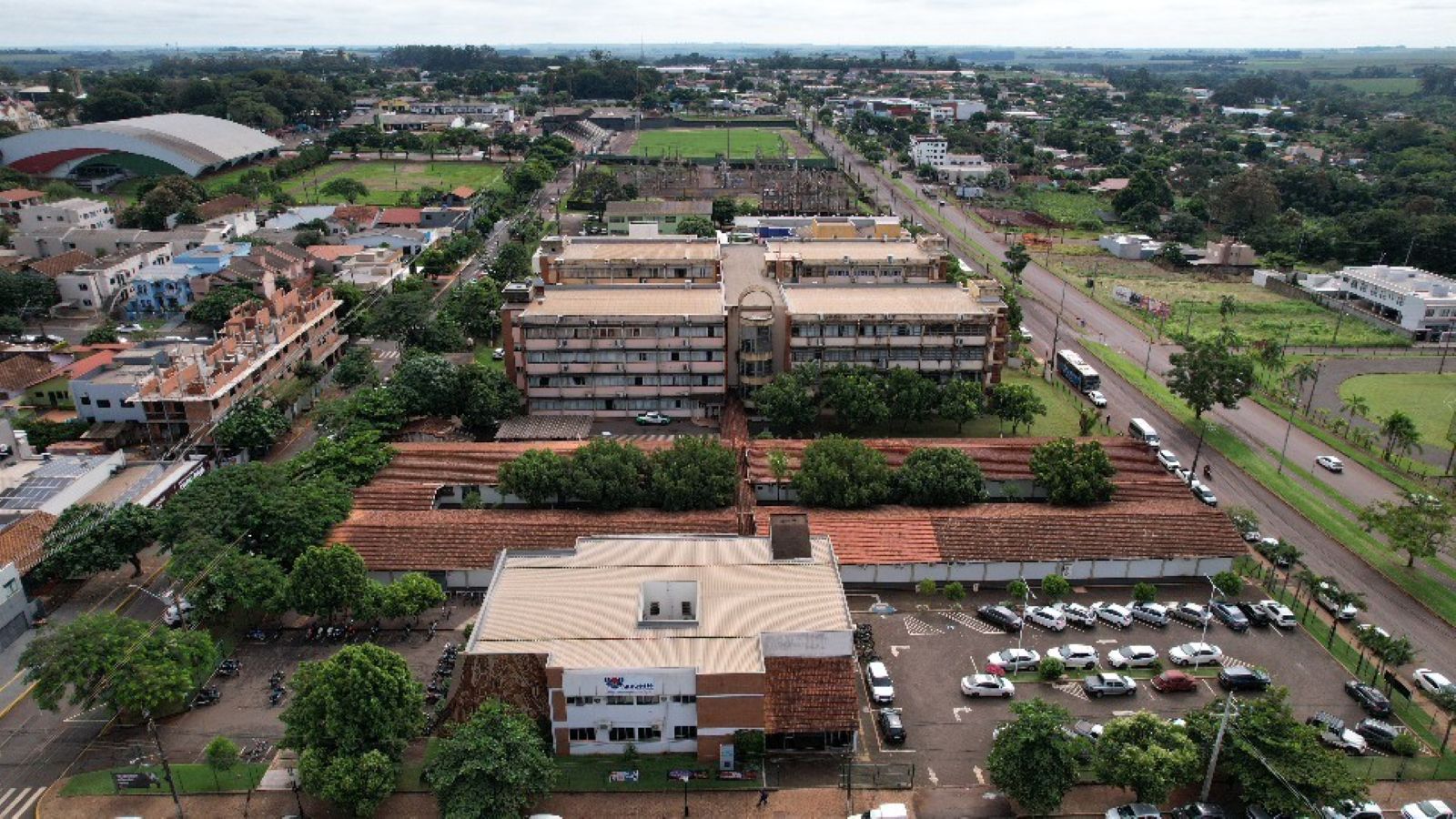 Campus da Unioeste em Marechal Cândido Rondon com estudantes caminhando em área arborizada