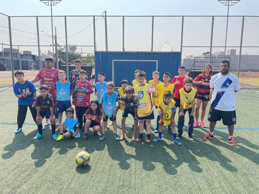 Crianças participando de atividades recreativas em campo de futebol com apoio do Projeto Redenção FC em Toledo