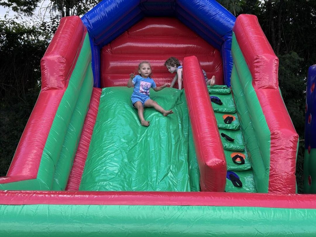 Criancas e familias brincando em brinquedos inflaveis durante evento recreativo em Toledo PR